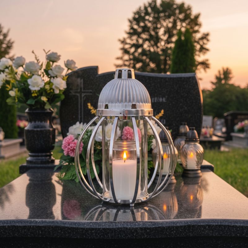 Znicz lampion srebrny, kula z drutów od frontu, zapalony na nagrobku o zmierzchu