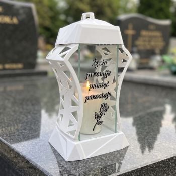 Znicz szklany biało-srebrny „Życie przemija” na nagrobku w słoneczny dzień