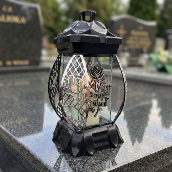 Znicz kapliczka czarno-srebrny „Kochanej Mamie” na nagrobku w słoneczny dzień